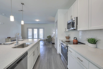 A modern kitchen with white cabinets and stainless steel appliances.